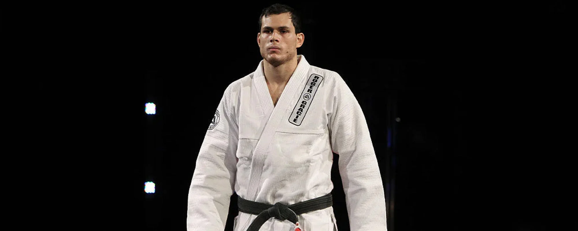 Roger Gracie in a white gi with black belt, arms crossed, official portrait