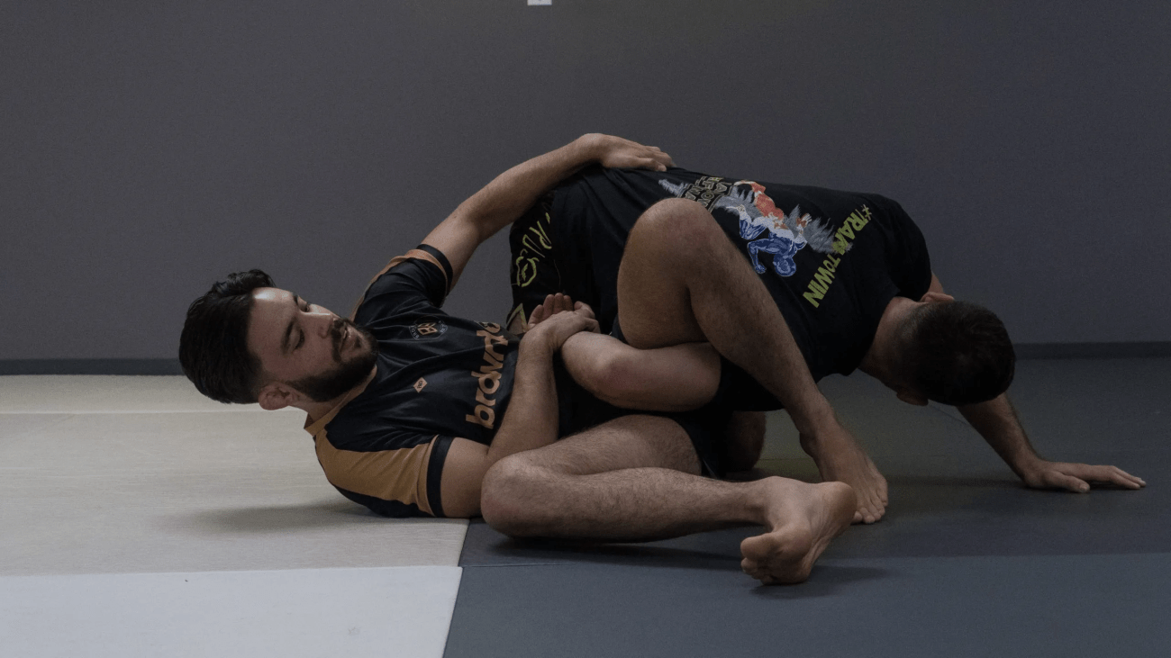 Omoplata setup showing leg trapping the opponent's arm