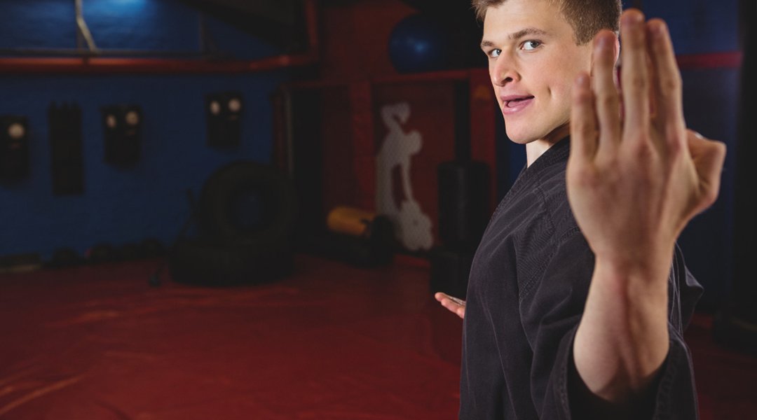 A BJJ referee raises the arm of a competitor in victory, demonstrating the fairness and sportsmanship of competition within defined weight classes.